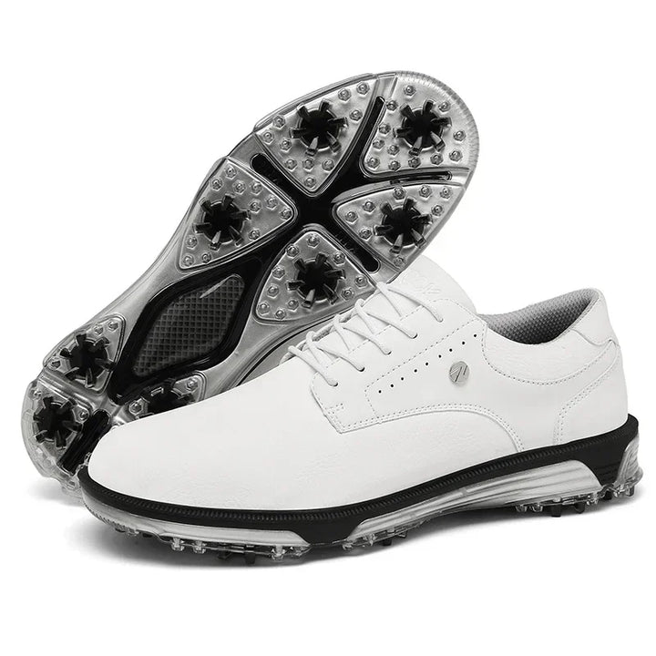 A pair of white golf shoes with a high-traction outsole and black, clear spiked soles. One shoe is upright while the other displays its textured sole with multiple black spikes for superior grip on the course.