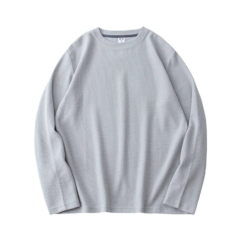 Light gray, heavyweight long-sleeve shirt laid flat on a white background. The premium cotton fabric has a subtle ribbed texture and appears soft and comfortable. The shirt features a relaxed, casual fit.