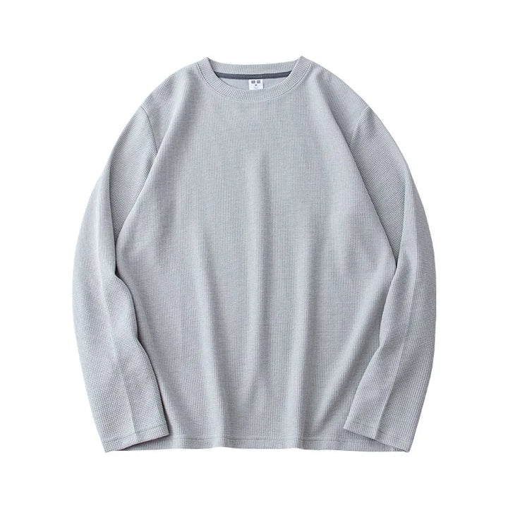 Light gray, heavyweight long-sleeve shirt laid flat on a white background. The premium cotton fabric has a subtle ribbed texture and appears soft and comfortable. The shirt features a relaxed, casual fit.