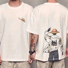 Front and back view of a white cotton knit crew neck T-shirt featuring a small straw hat graphic art on the front and a large illustration of a character in a straw hat and camouflage jacket on the back.