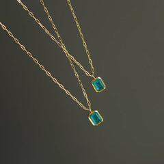 Two delicate 18K gold plated chains with rectangular green zirconia pendants are displayed against a plain dark background.