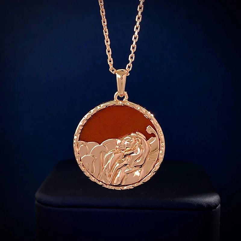 Gold pendant necklace featuring a round medallion with a raised lion head design and subtle copper finish, perfect as astrology jewelry, displayed on a dark surface.