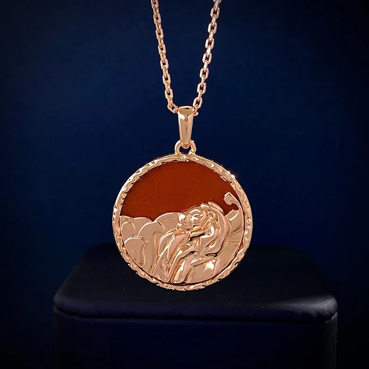 Gold pendant necklace featuring a round medallion with a raised lion head design and subtle copper finish, perfect as astrology jewelry, displayed on a dark surface.