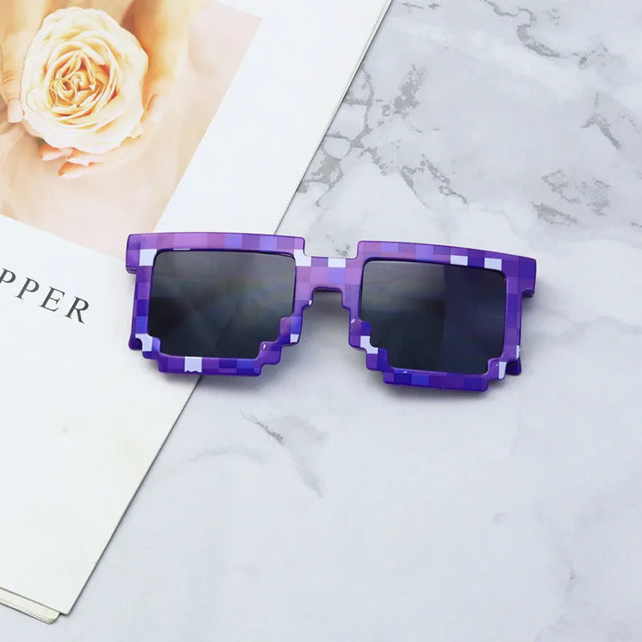Purple pixelated sunglasses with scratch-resistant lenses and black frames rest on a marble surface next to an open magazine showing a close-up of a light peach-colored rose.