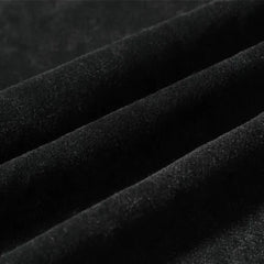 Close-up of black velvet fabric with soft texture, showing ridges and folds that highlight its smooth, luxurious surface—ideal for graphic design projects or pairing with an oversized fit.