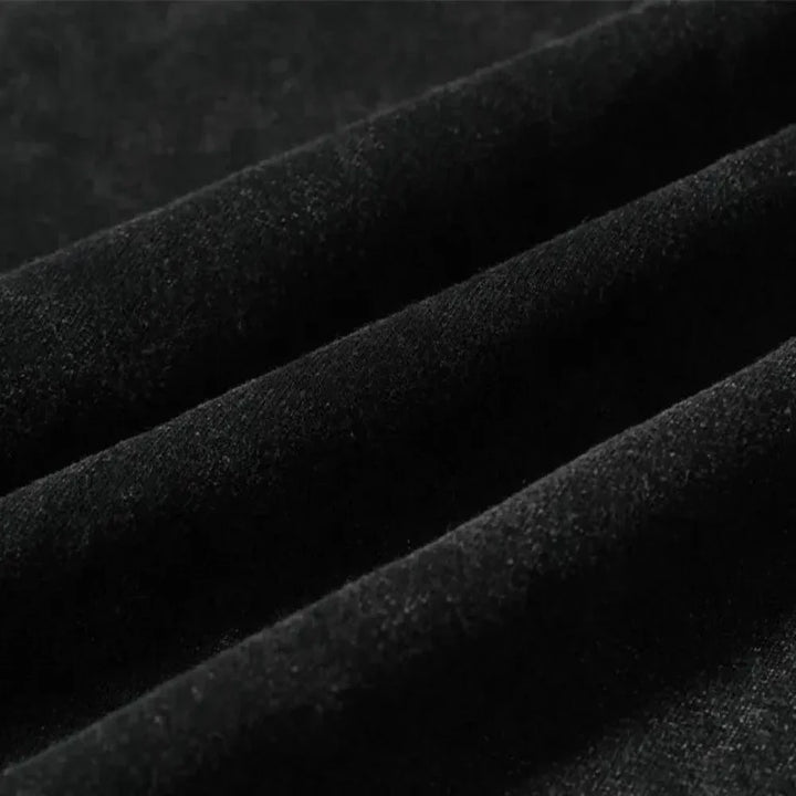 Close-up of black velvet fabric with soft texture, showing ridges and folds that highlight its smooth, luxurious surface—ideal for graphic design projects or pairing with an oversized fit.