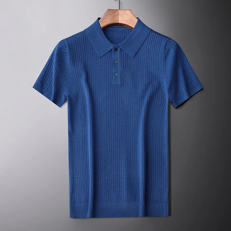 A blue high-end knitted polo shirt with a textured pattern, slim fit, collar, and three buttons is displayed hanging on a wooden hanger against a plain gray background.