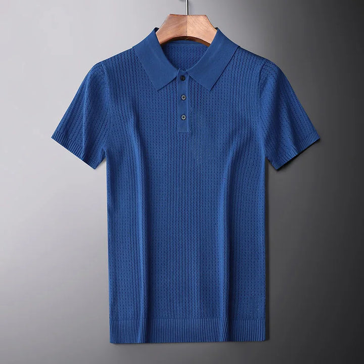 A blue high-end knitted polo shirt with a textured pattern, slim fit, collar, and three buttons is displayed hanging on a wooden hanger against a plain gray background.