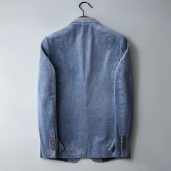 A light blue slim-fit corduroy blazer hangs on a black hanger against a plain light gray background, shown from the back with visible sleeve buttons and subtle texture.