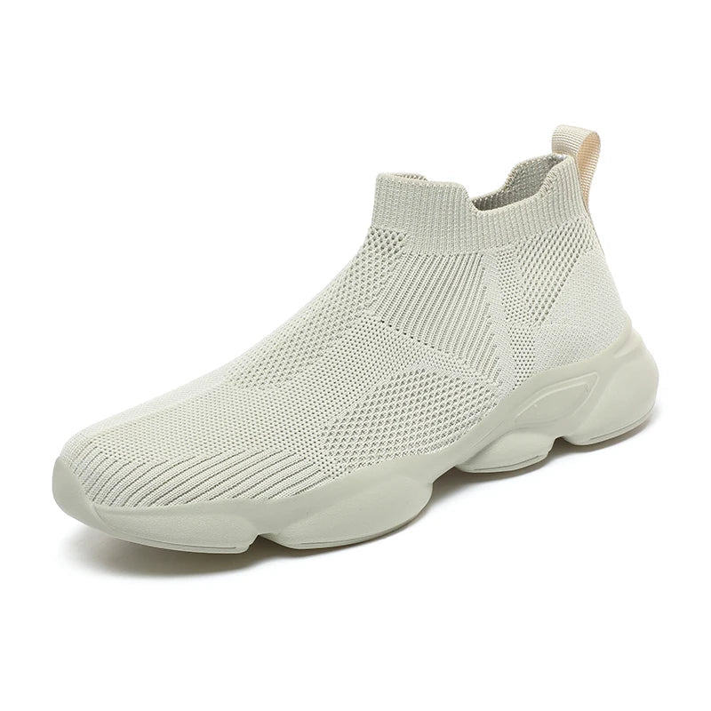 A light beige slip-on sneaker with a lightweight, breathable knit fabric upper, a ribbed sock-like ankle collar, and a chunky, textured rubber sole.