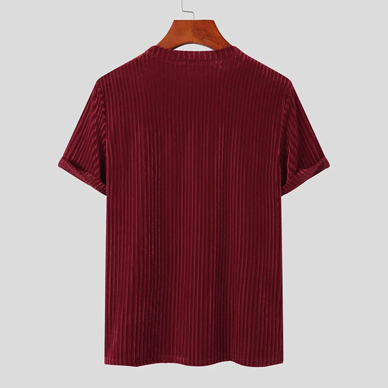 A short-sleeved, stripe corduroy tee in deep burgundy with a classic fit, displayed on a wooden hanger against a plain light gray background, shown from the back.