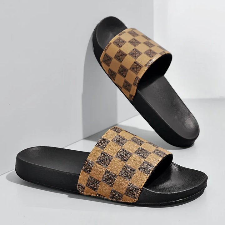 A pair of black streetwear slides with brown and black checkerboard-patterned straps, styled against a white background for a bold, checkered sandals look.