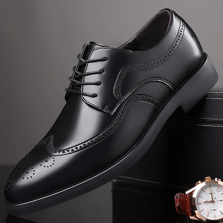 A single black leather dress shoe with brogue detailing and decorative stitching is displayed at an angle on a dark surface, with part of a wristwatch visible in the lower right corner.