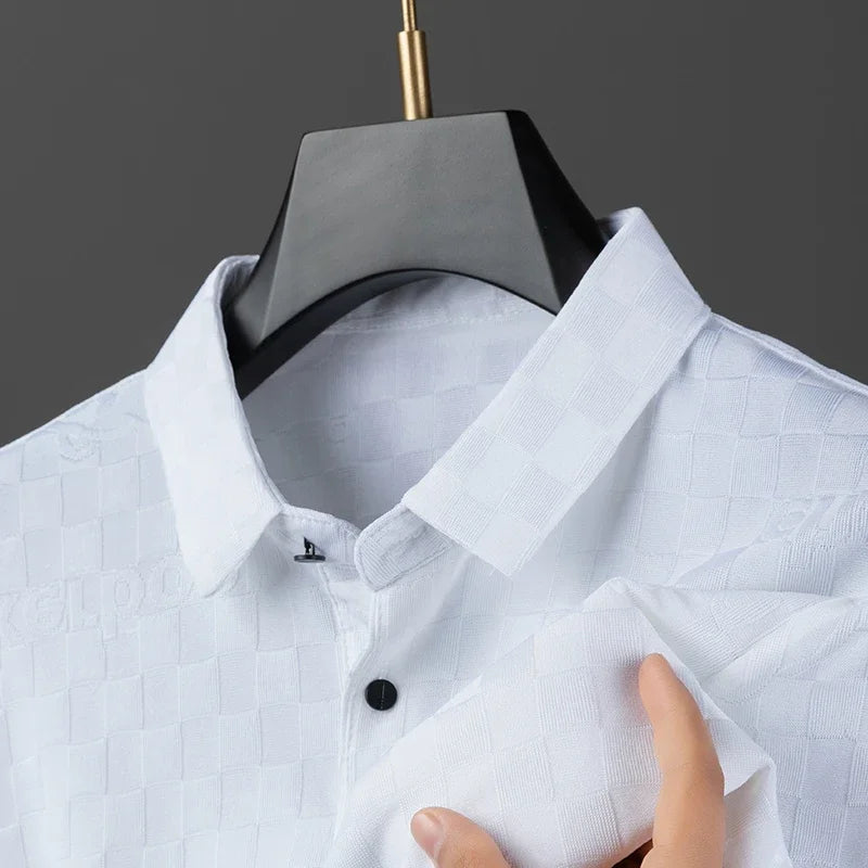 A close-up of a tailored fit white shirt in a checkerboard pattern, hanging on a black hanger with a hand holding part of it. The shirt features a collar and black buttons against a gray background.
