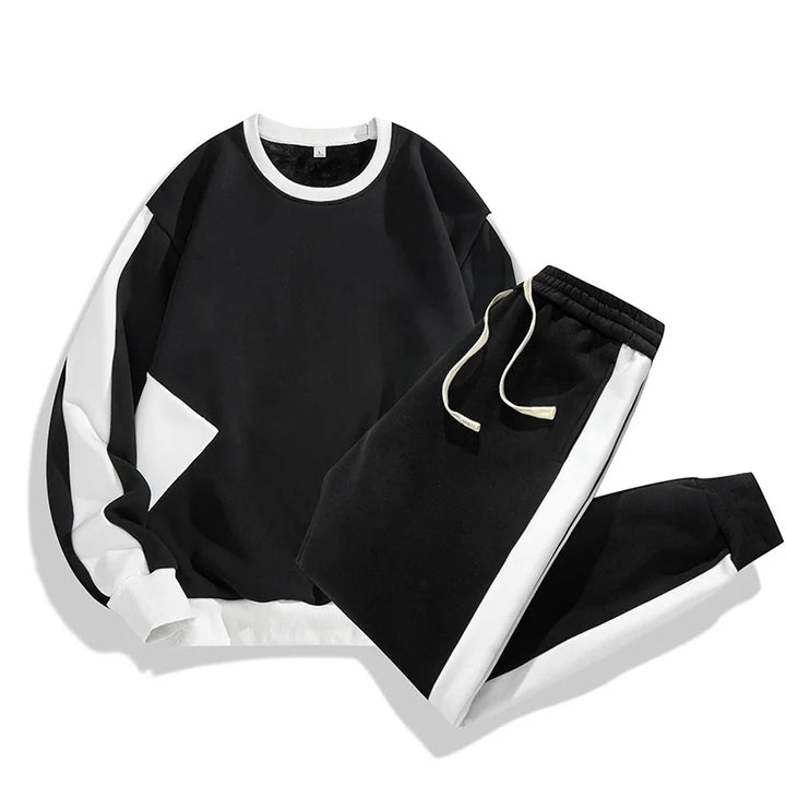 A black and white matching tracksuit set in a soft cotton blend, featuring a long-sleeve crewneck sweatshirt and drawstring pants with contrasting white panels—perfect casual loungewear with a relaxed fit.