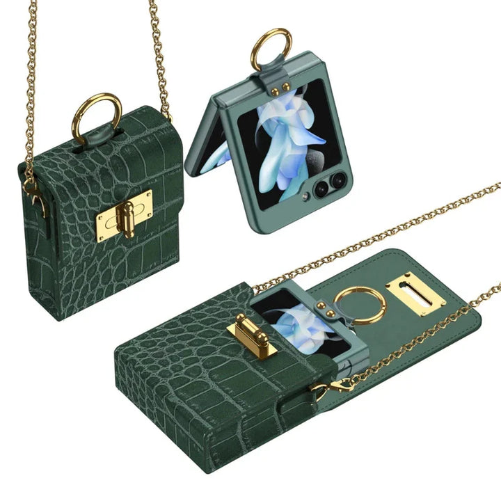 Small, dark green, crocodile-textured purse with a gold chain and clasp, shown open and closed, holding a foldable smartphone in a leather phone case with a blue flower on its screen.