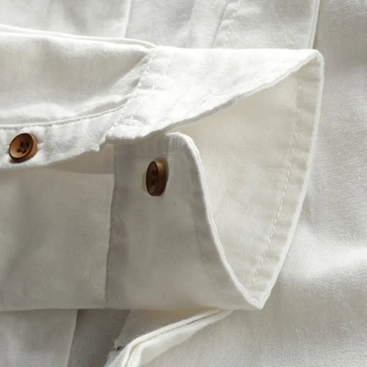 Close-up of a Japanese inspired overshirt’s white cuff with brown buttons, highlighting the 100% cotton fabric’s texture and detailed stitching.
