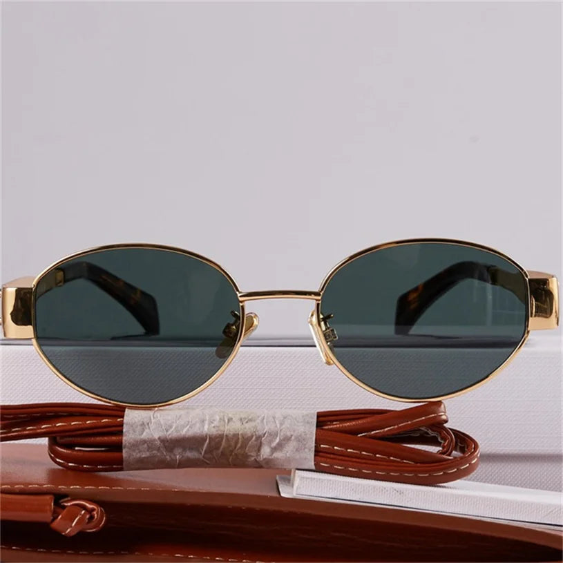 A pair of vintage-inspired sunglasses with gold metal frames and dark lenses is displayed against a white background, with a brown leather case and matching strap beneath them, blending timeless Italian style with UV400 protection.