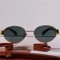 A pair of vintage-inspired sunglasses with gold metal frames and dark lenses is displayed against a white background, with a brown leather case and matching strap beneath them, blending timeless Italian style with UV400 protection.