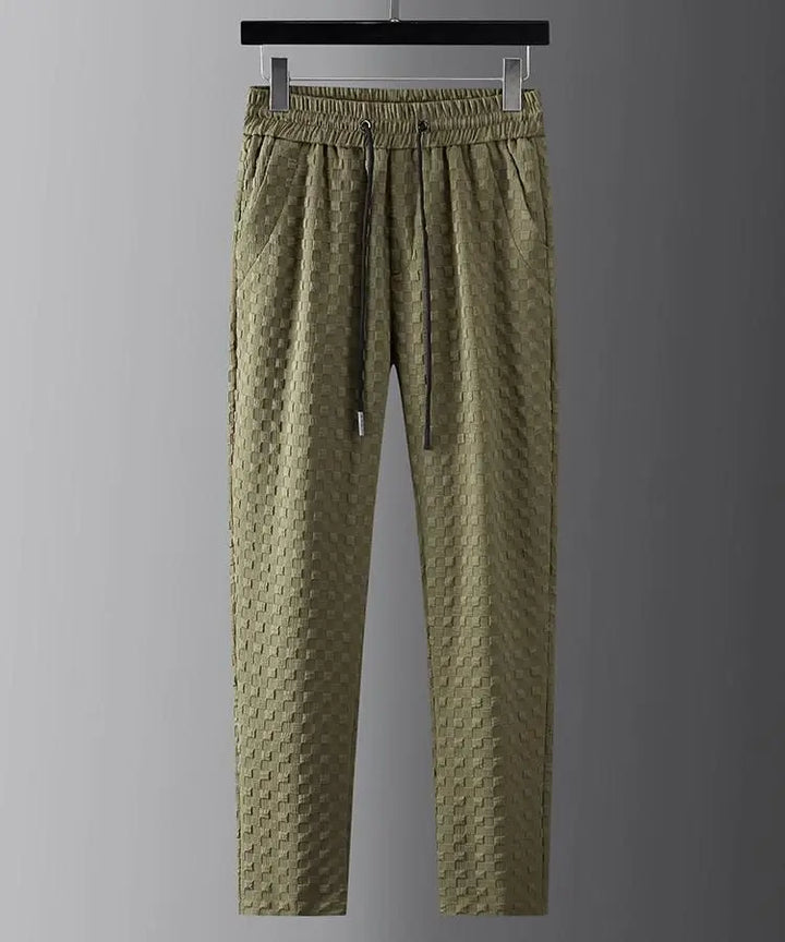 Olive green textured jogger pants with an elastic drawstring waistband, ultra-soft fabric, and side pockets, hanging on a black clothes hanger against a plain gray background.