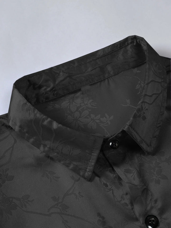 Close-up of a black collared shirt with a subtle floral pattern and black buttons, crafted from breathable fabric—perfect for men's summer shirts, displayed against a light background.