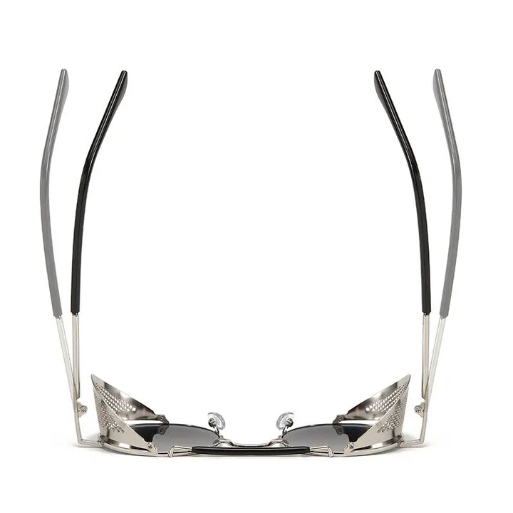 A pair of Steampunk sunglasses viewed from the front with the arms raised, showing silver frames, black tips, and reflective lenses. The design appears futuristic and angular with bold metallic vibes.