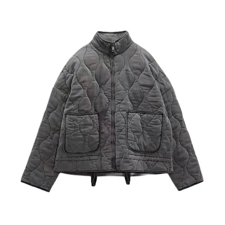 A gray quilted bomber jacket with a high collar, front zipper closure, padded insulation, two large front pockets, and a slightly cropped, boxy silhouette.