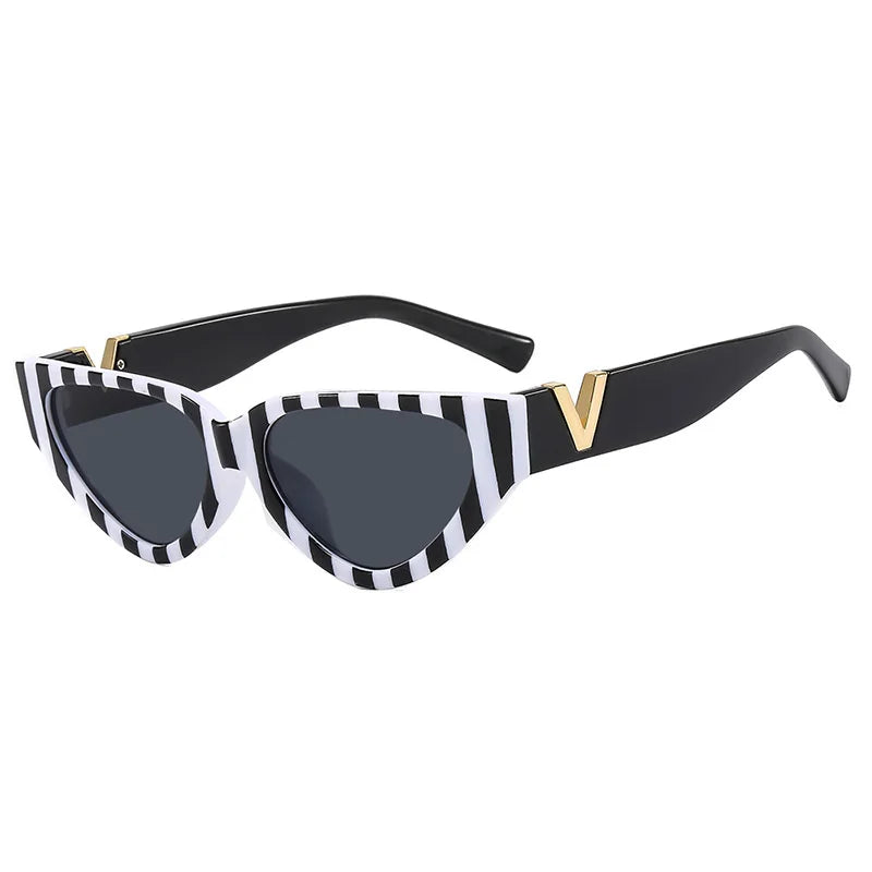 Black vintage cat eye sunglasses with bold white and black stripes on the front frame, UV400 protection, dark tinted lenses, and a gold V detail at the temples. The arms are solid black.