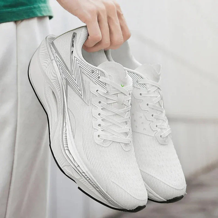 A person in light clothing holds a pair of clean, white running shoes with black soles, featuring a subtle gray zigzag design and an ultra-lightweight, shock-absorbing sole. The background is softly blurred.