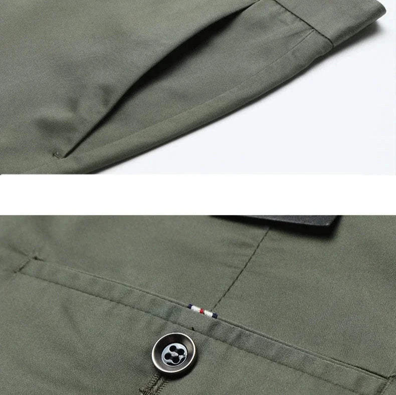 Close-up of olive green pants featuring a slanted side pocket above and a back pocket with button and stitched flag detail below, showcasing their 4 way stretch fabric for versatile style.