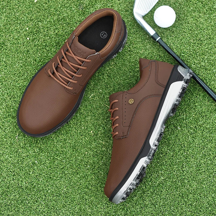 A pair of brown golf shoes with a breathable mesh lining rests on green artificial grass next to a golf club and a golf ball.