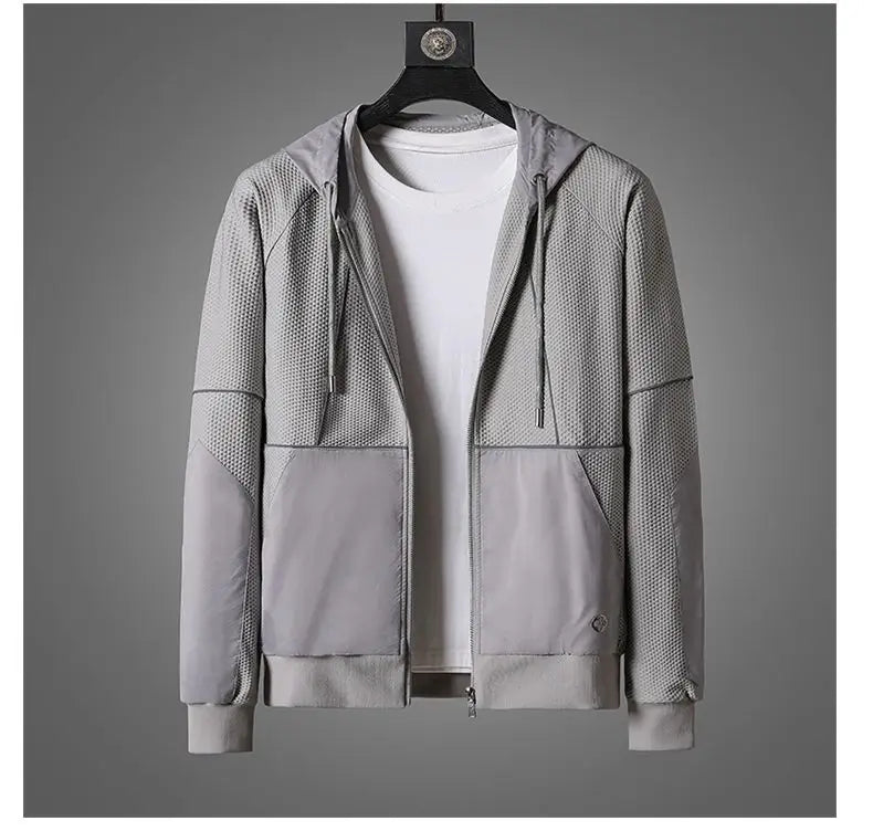 A light gray zipper hoodie with mesh-textured panels and moisture wicking fabric is displayed on a hanger over a plain white T-shirt, set against a neutral gray background.