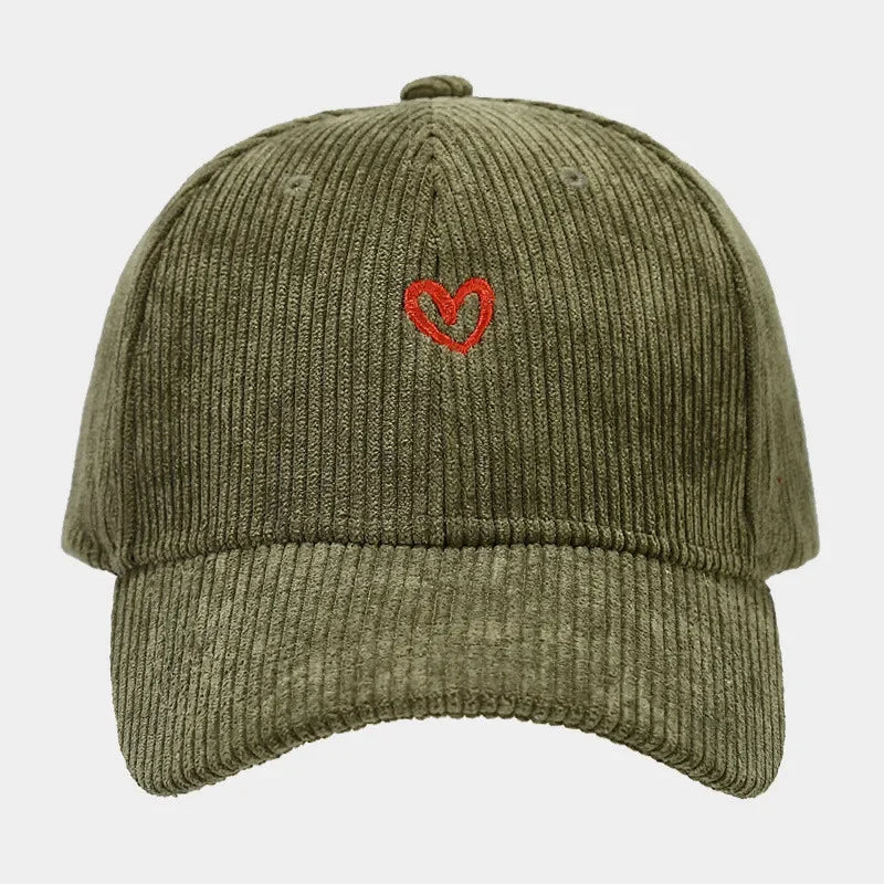 A green corduroy baseball cap featuring a small red heart embroidery on the front center, combining classic style with the unique texture of corduroy hats.