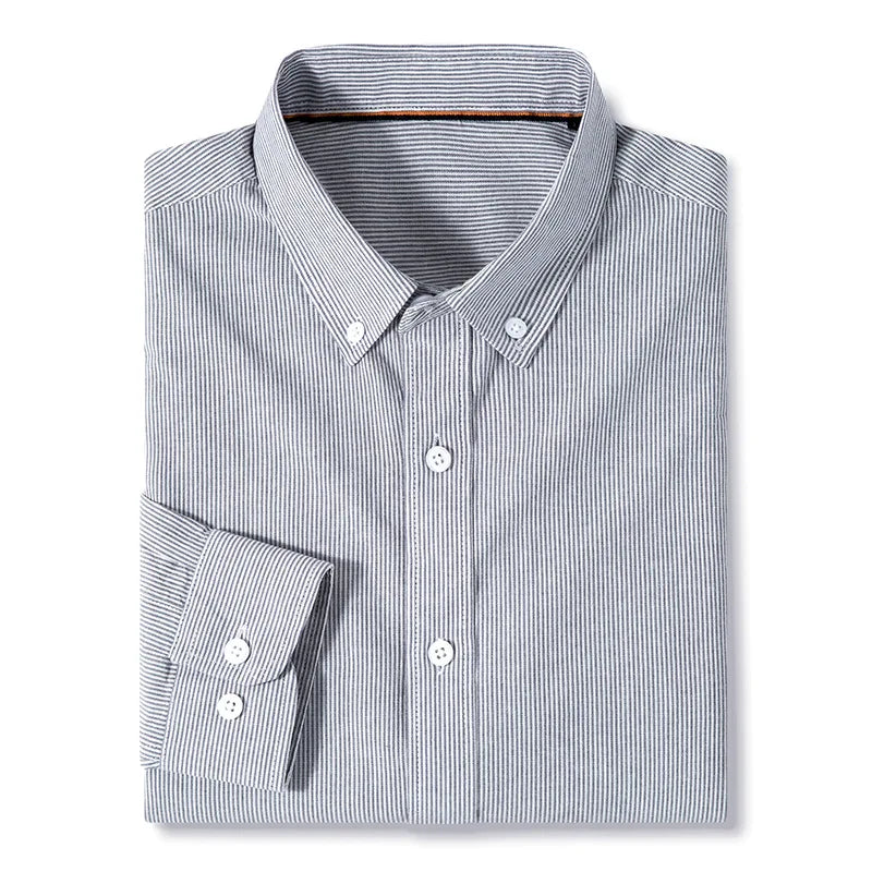 A classic pinstripe shirt, this neatly folded long-sleeve cotton button-up features thin vertical black and white stripes with white buttons, set against a plain white background.
