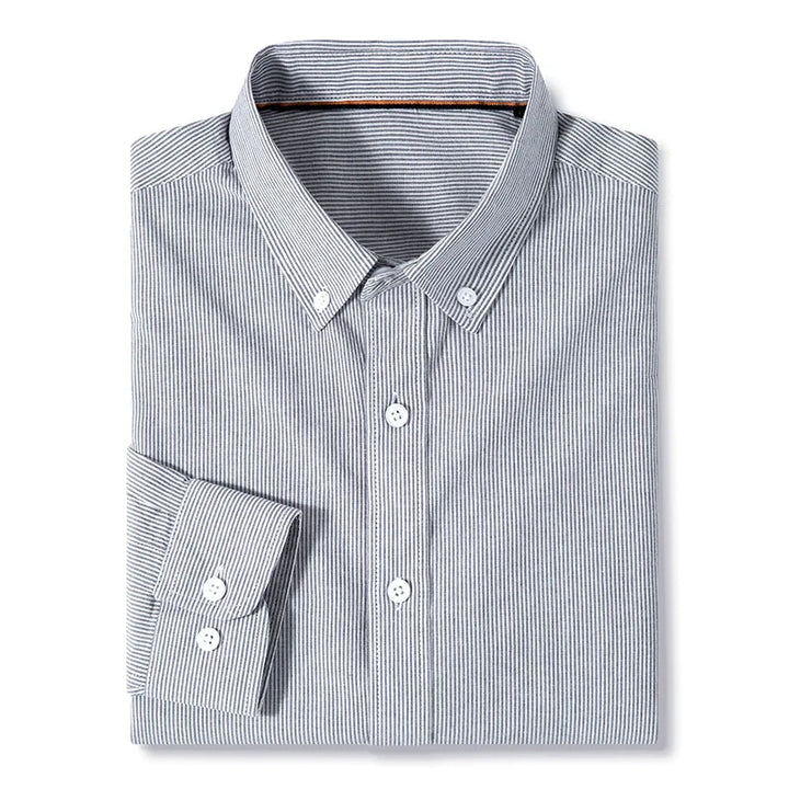 A classic pinstripe shirt, this neatly folded long-sleeve cotton button-up features thin vertical black and white stripes with white buttons, set against a plain white background.