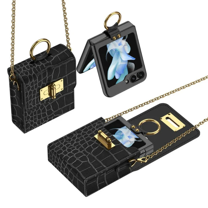 A black faux-crocodile leather phone case with a gold chain and clasp, shown with a foldable smartphone inside. The case resembles a small handbag, features a built-in ring holder, and includes an optional crossbody strap.