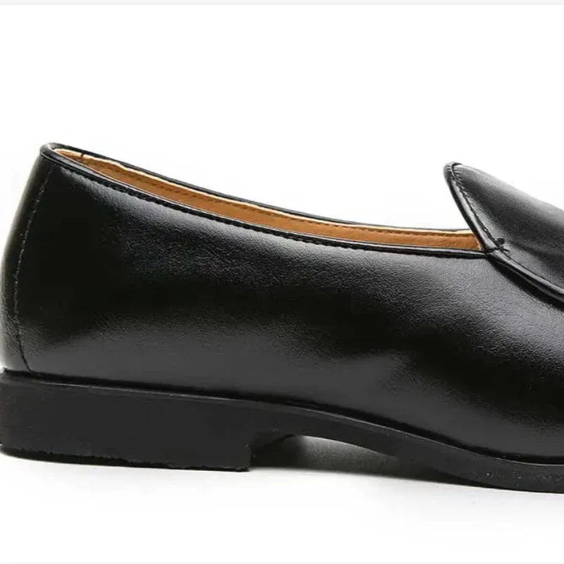 A black leather slip-on dress shoe with a low heel and cushioned insole, shown from the side against a white background.