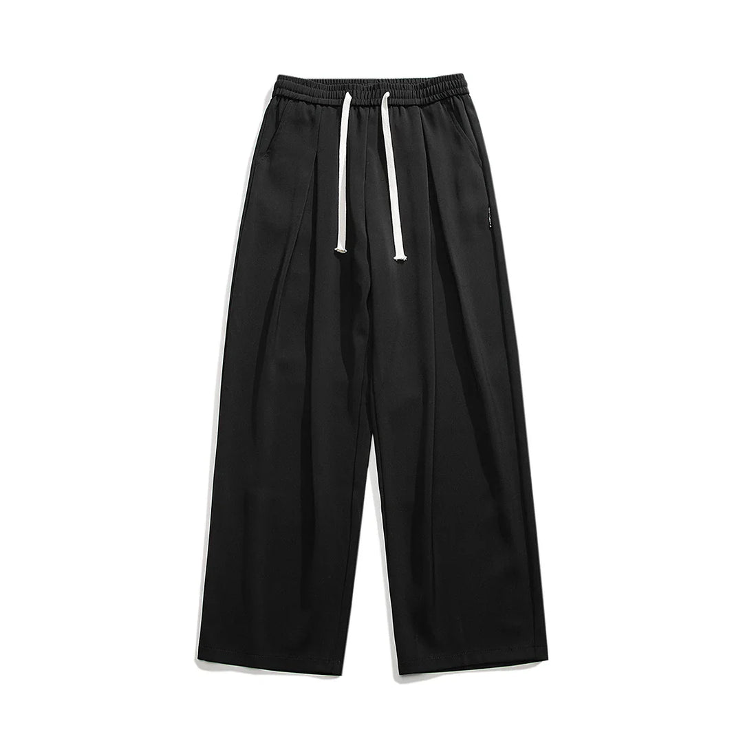 Wide-leg black streetwear joggers with an elastic waistband and white drawstrings, crafted from soft ice-silk fabric, laid flat on a white background.