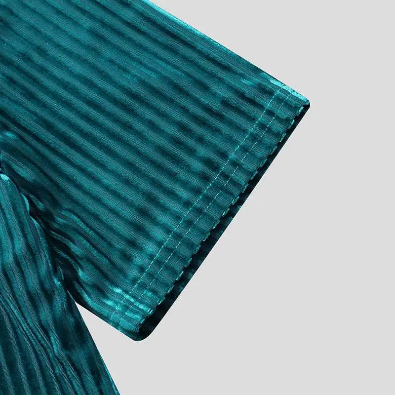 Close-up of a teal-colored, short-sleeve stripe corduroy tee with a shiny, textured, vertical striped pattern and classic fit, set against a plain light gray background.