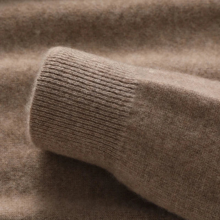 Close-up of a soft, brown pure wool sweater sleeve laid flat, highlighting the ribbed cuff and fuzzy wool craftsmanship.