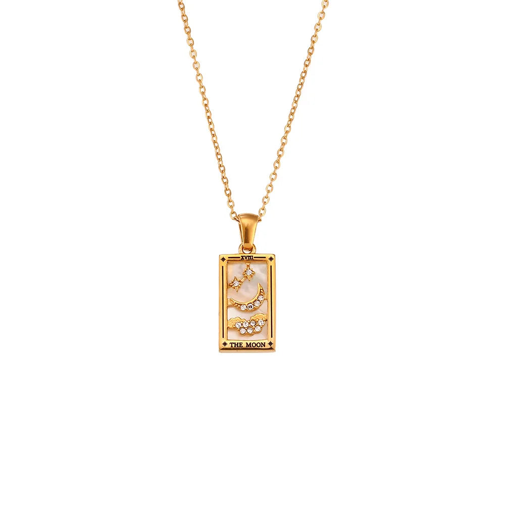 The Solaris Pendant Necklace is an 18K gold-plated chain featuring a rectangular pendant with a crescent moon, stars, blue enamel accents, and crystal details. The bottom of the pendant is inscribed with THE MOON.