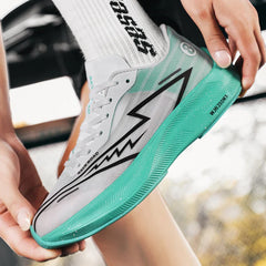 A person wearing a white athletic shoe with a turquoise, shock-absorbing sole and black lightning bolt design adjusts the laces. The person is also wearing white socks with black text.