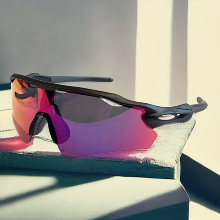 A pair of sporty Polarized Cycling Sunglasses with large, reflective, purple-tinted lenses and a black frame sits on a light green fabric surface in sunlight.