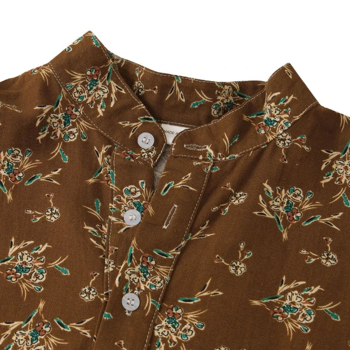 Brown cotton shirt with a mandarin collar, floral print in green and cream, and white buttons down the front. The lightweight fabric and classic design make it perfect for casual wear.