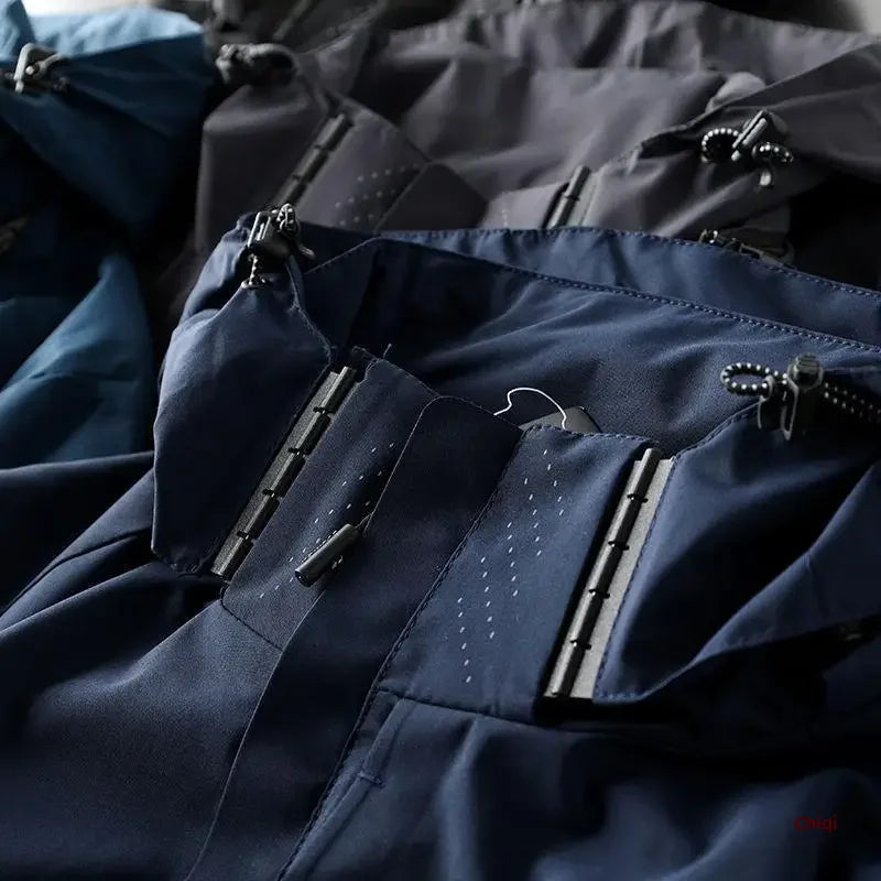 Close-up of blue and gray waterproof jackets with zipper and drawstring details, highlighting the fabric texture and durable, weather-resistant construction.