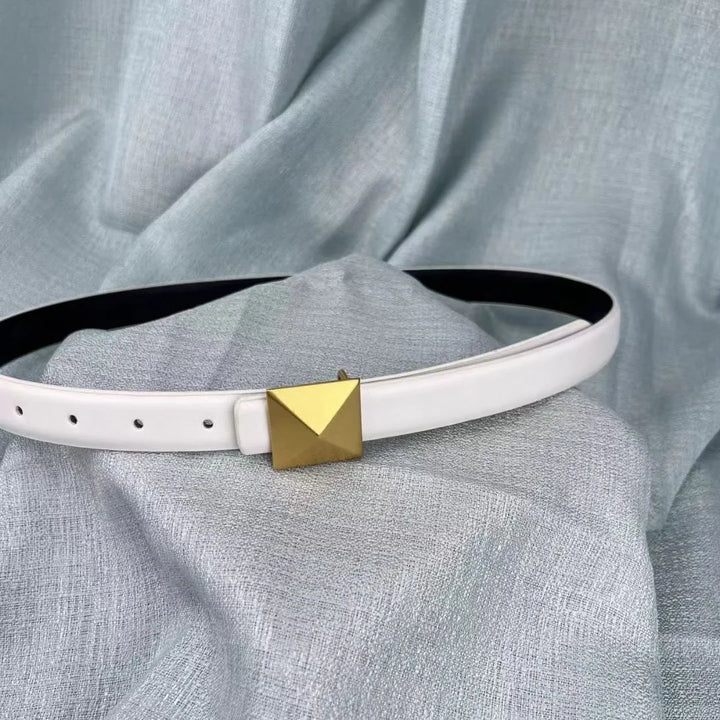 A white leather belt with an adjustable length and a gold pyramid-shaped buckle is displayed on a light blue textured fabric background.
