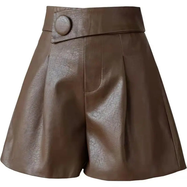 High-waisted brown calfskin leather shorts with a wide waistband, large round button detail on the left side, pleats in front, and a slightly flared leg.