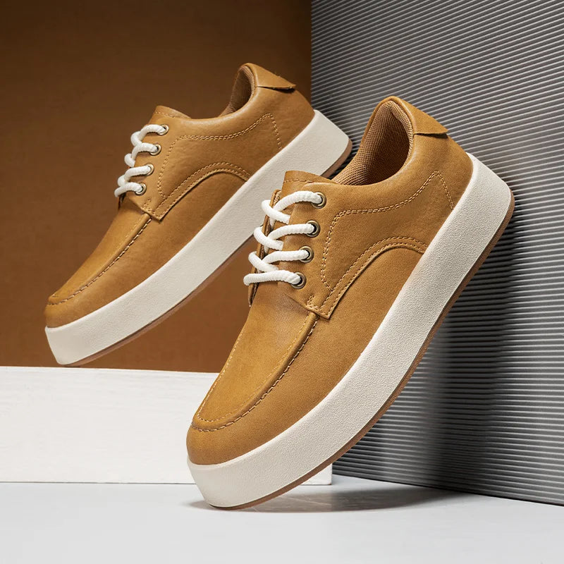 A pair of tan suede sneakers inspired by Italian designer shoes, featuring white laces and thick white soles, displayed against a modern background with brown and gray tones.
