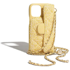 A yellow quilted phone case with a matching attached pouch and a stylish chain strap, decorated with pearl accents, is displayed upright on a white background.