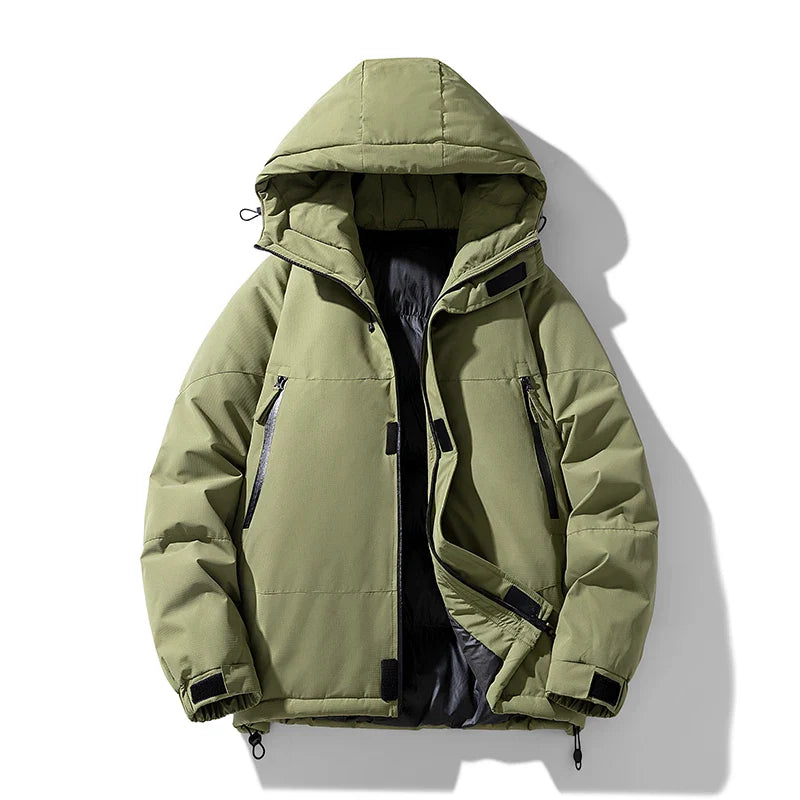 Light olive green windproof puffer jacket with a detachable hood, black zipper and pocket details, adjustable cuffs, and a partially open front revealing a dark inner lining. The insulated jacket is displayed against a white background.